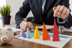 Fractional marketing leader analyzing colorful cone graphs on a growth chart at a modern desk setup.