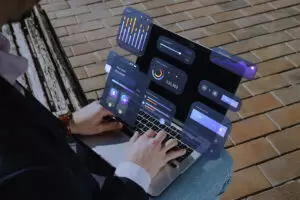 Fractional marketing leader working remotely on a laptop with digital dashboards, analytics, and performance metrics displayed in an augmented interface.